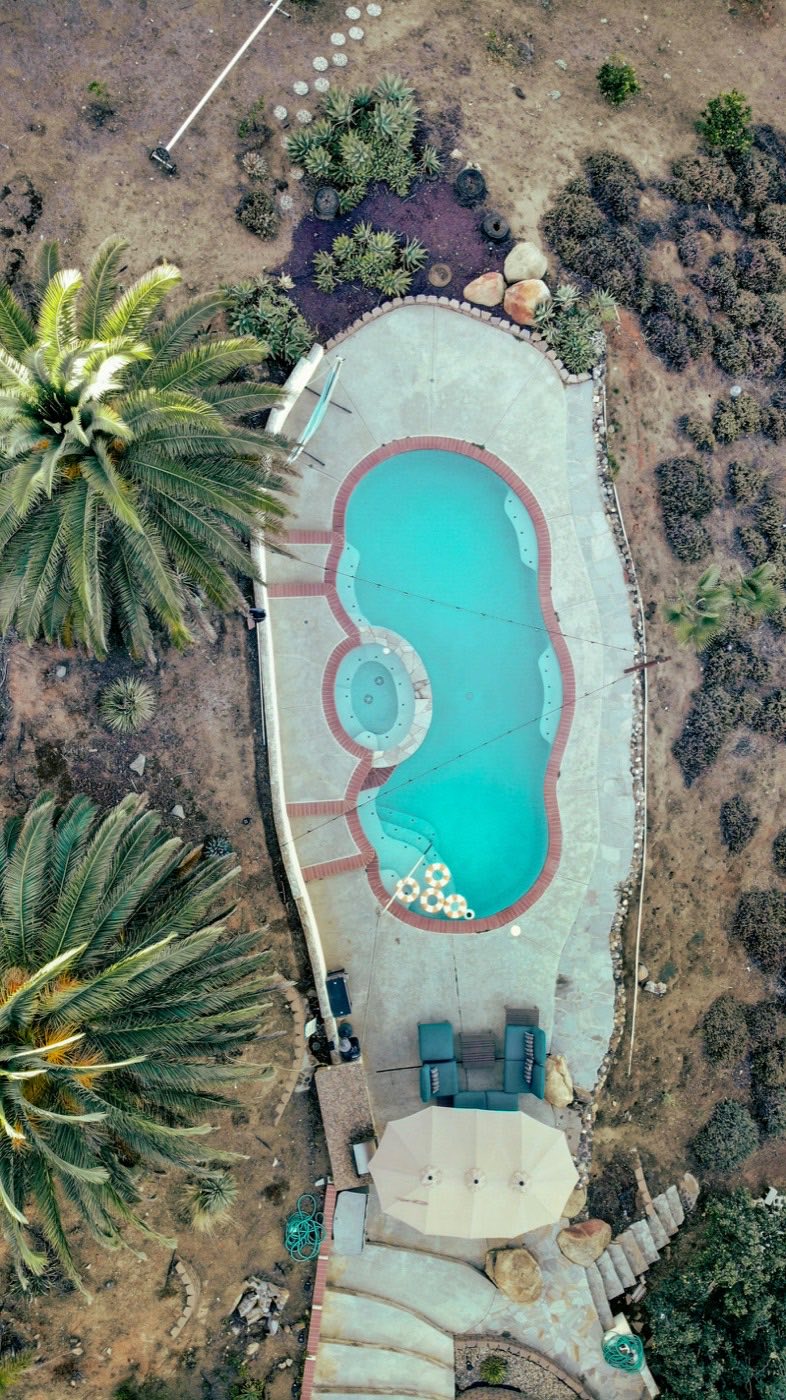 Overhead view of a freeform pool with an attached round spa.