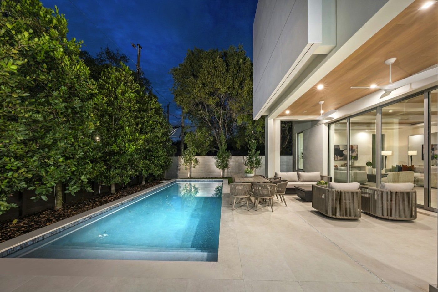 Modern home with a pool and a covered outdoor seating area.